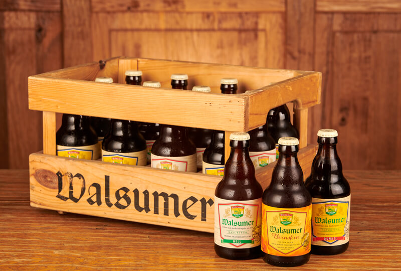 Drei Flaschen Bier vor einem Holzkasten 