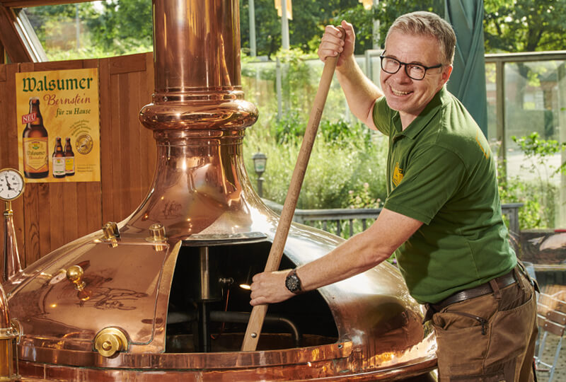 Brauer rührt in einem großen Kessel